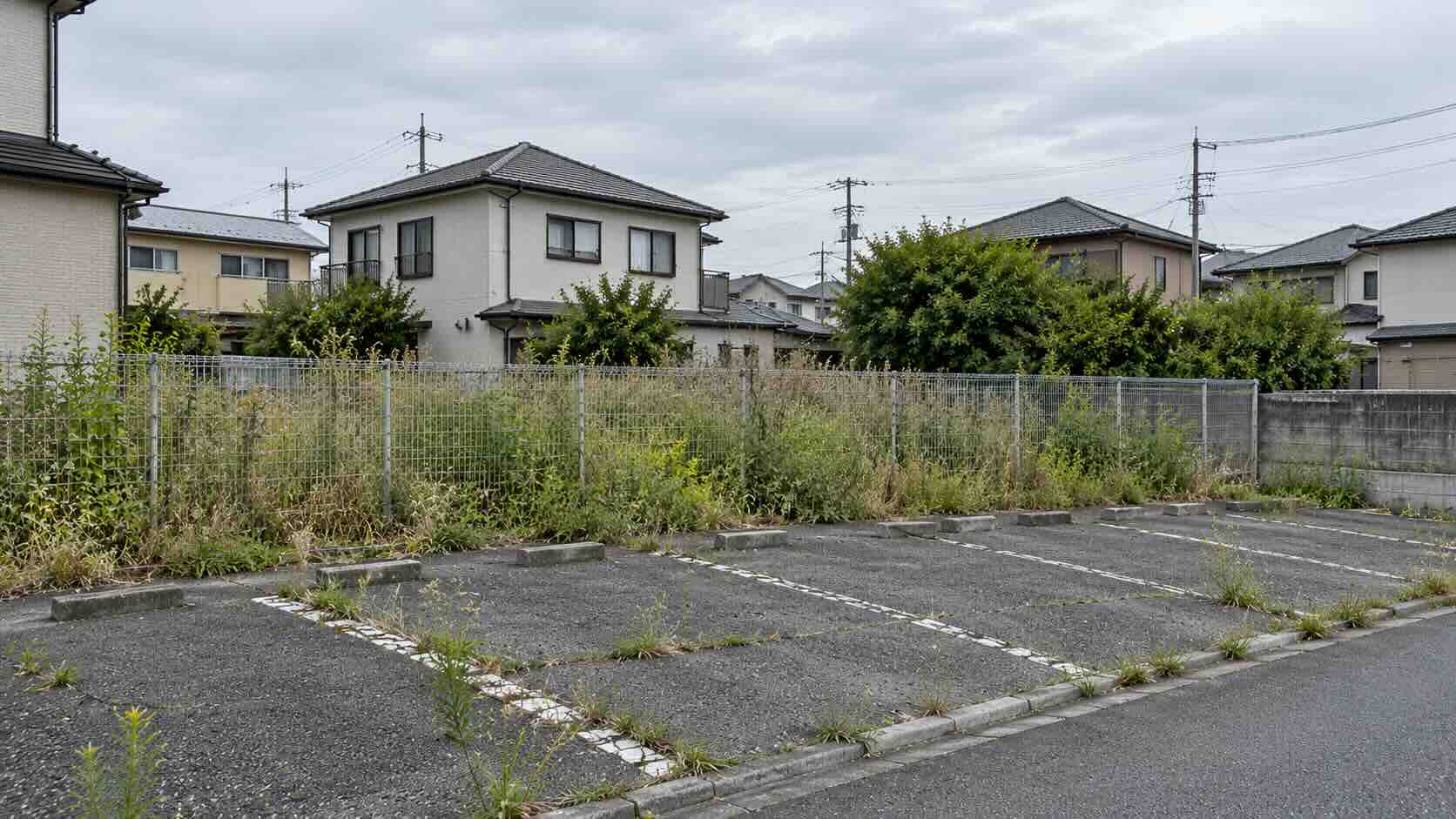 使われていない更地と、区画の空いた月極駐車場